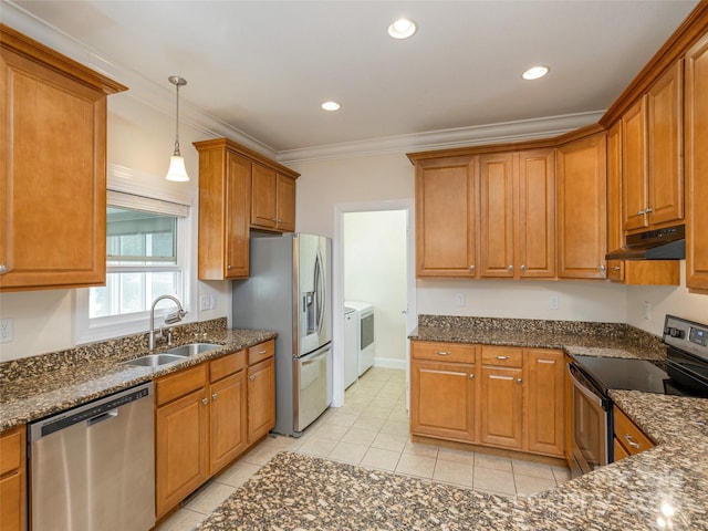 kitchen featuring appliances with stainless steel finishes, brown cabinetry, a sink, independent washer and dryer, and under cabinet range hood