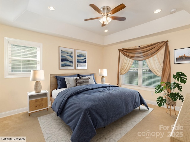 carpeted bedroom featuring a tray ceiling, ceiling fan, baseboards, and recessed lighting