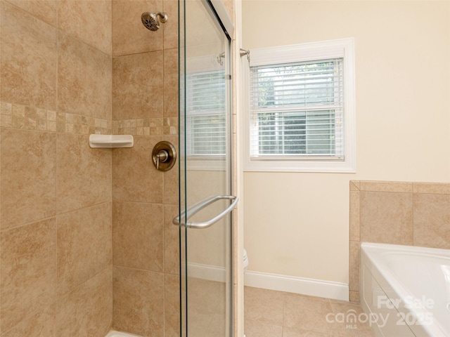 full bath featuring a stall shower, tile patterned flooring, baseboards, and a bath