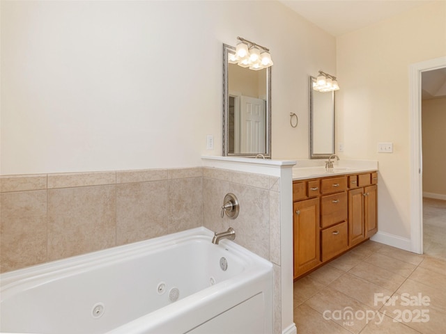 full bathroom with a whirlpool tub, baseboards, vanity, and tile patterned floors