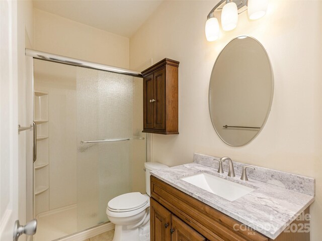 bathroom featuring toilet, an enclosed shower, and vanity