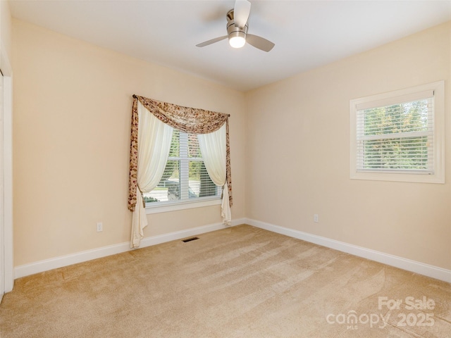 unfurnished room with visible vents, baseboards, and light colored carpet