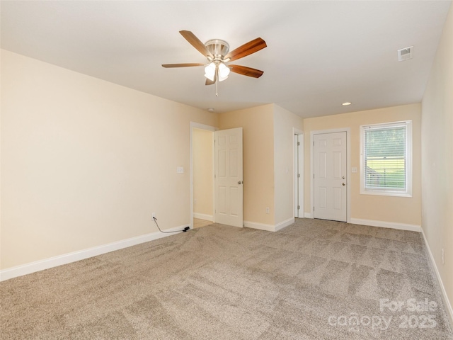 carpeted spare room with ceiling fan and baseboards