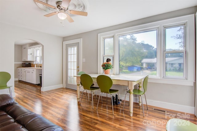 dining area with wood-type flooring, ceiling fan, and sink