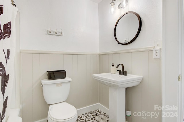 bathroom with toilet and a shower with shower curtain