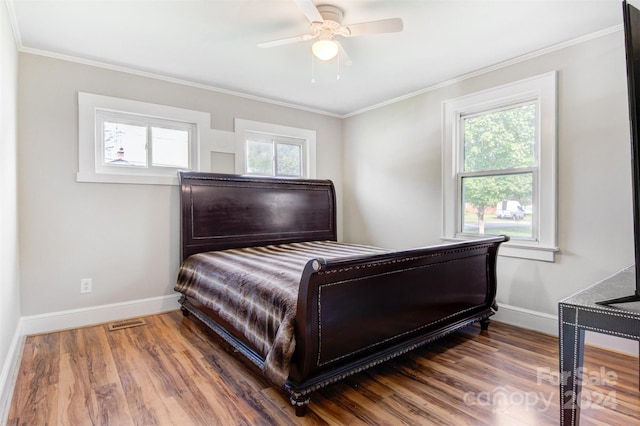 bedroom with crown molding, dark hardwood / wood-style floors, and ceiling fan