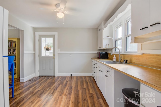 kitchen featuring ceiling fan, dark wood-type flooring, sink, and white cabinetry