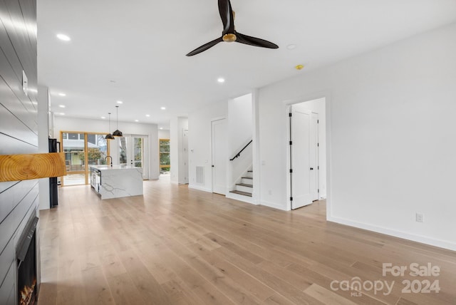 unfurnished living room featuring ceiling fan and light hardwood / wood-style floors