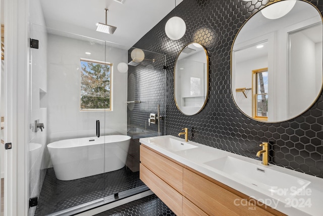 bathroom with decorative backsplash, shower with separate bathtub, vanity, and tile walls