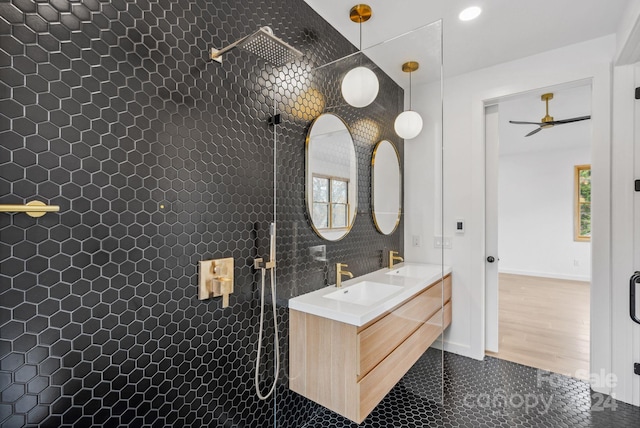 bathroom featuring hardwood / wood-style floors, vanity, ceiling fan, and a tile shower