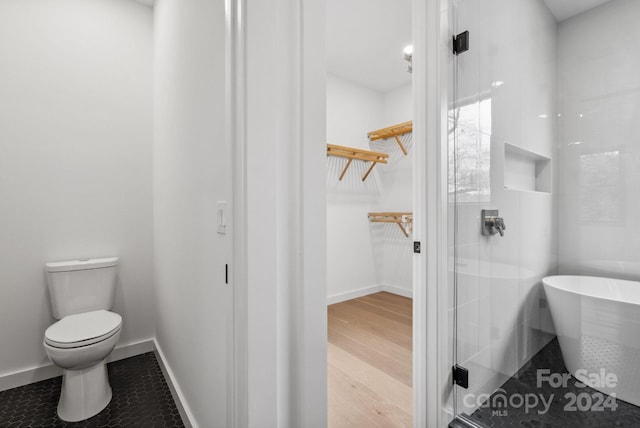 bathroom with hardwood / wood-style flooring, toilet, and shower with separate bathtub