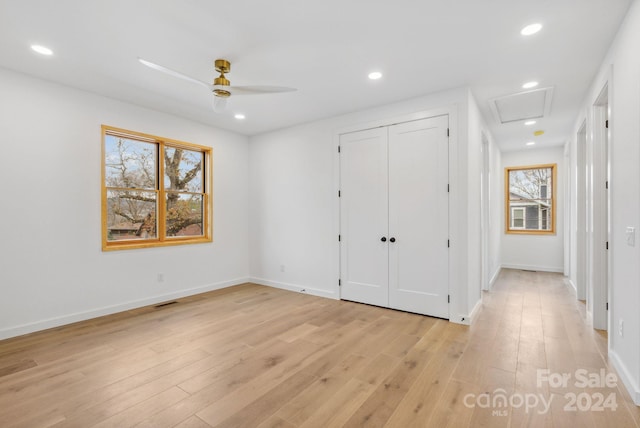 unfurnished bedroom featuring a closet, light hardwood / wood-style flooring, and ceiling fan