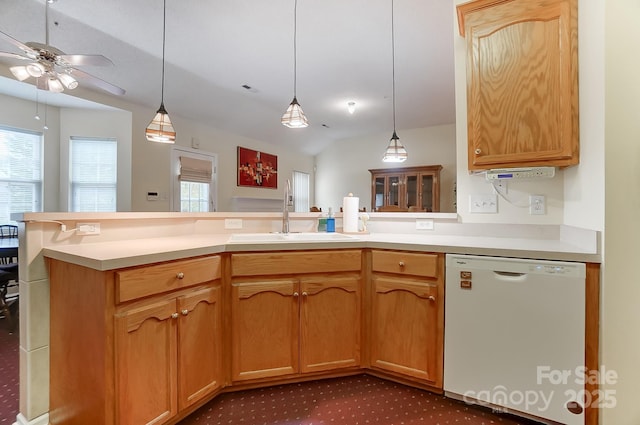 kitchen with plenty of natural light, a peninsula, white dishwasher, and a sink