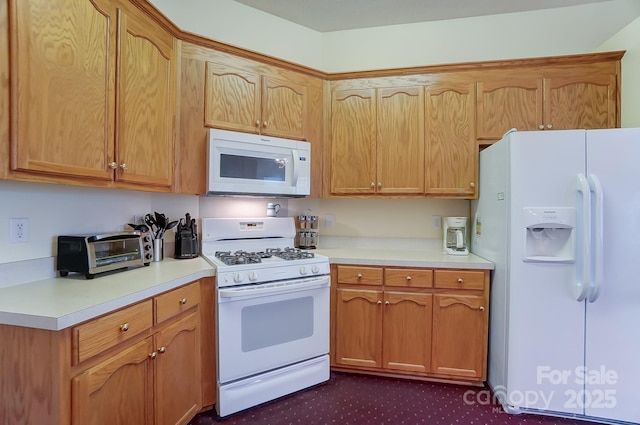 kitchen featuring light countertops, white appliances, and a toaster