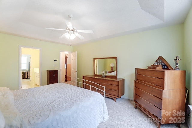 bedroom featuring connected bathroom, a ceiling fan, and light colored carpet