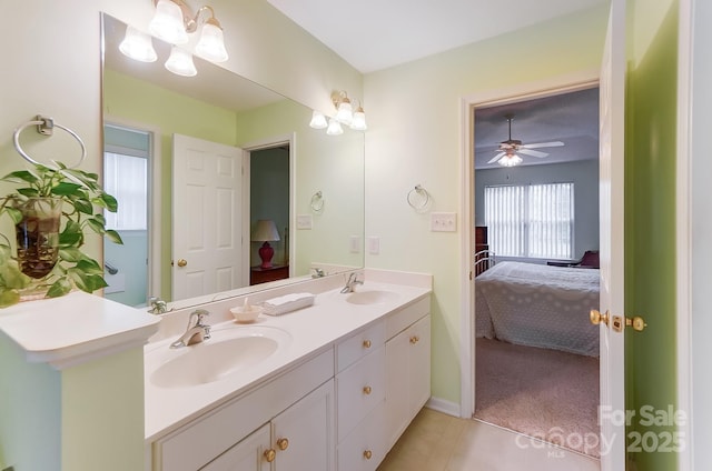 ensuite bathroom featuring tile patterned flooring, connected bathroom, a sink, and double vanity