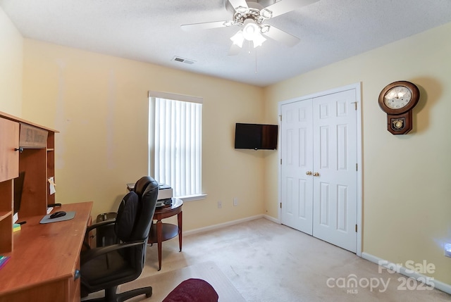 office space with light carpet, baseboards, visible vents, and a ceiling fan