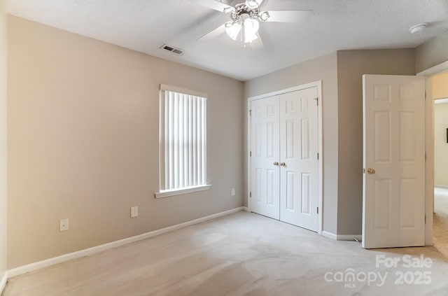 unfurnished bedroom featuring a closet, carpet, visible vents, and baseboards