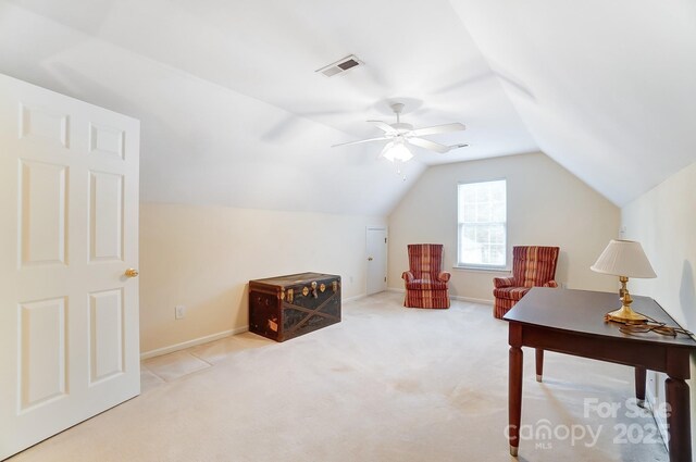 interior space featuring carpet floors, a ceiling fan, visible vents, vaulted ceiling, and baseboards