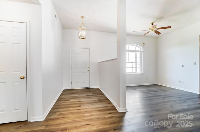 foyer entrance featuring baseboards, wood finished floors, and ceiling fan