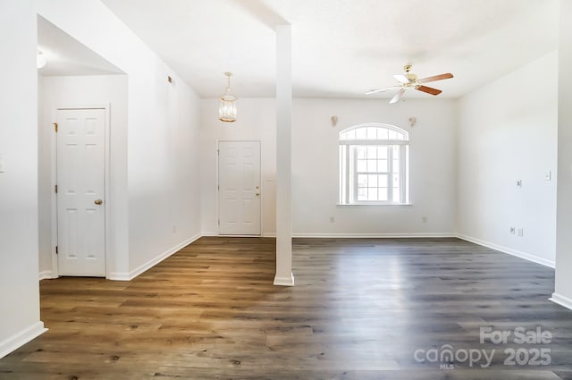 unfurnished room with baseboards, wood finished floors, and ceiling fan with notable chandelier