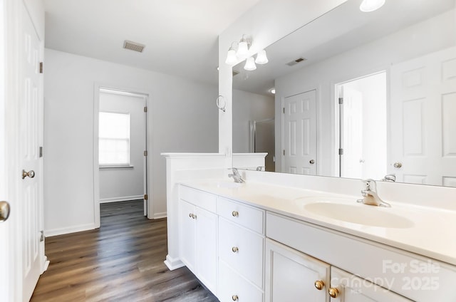 bathroom with baseboards, a sink, visible vents, and double vanity