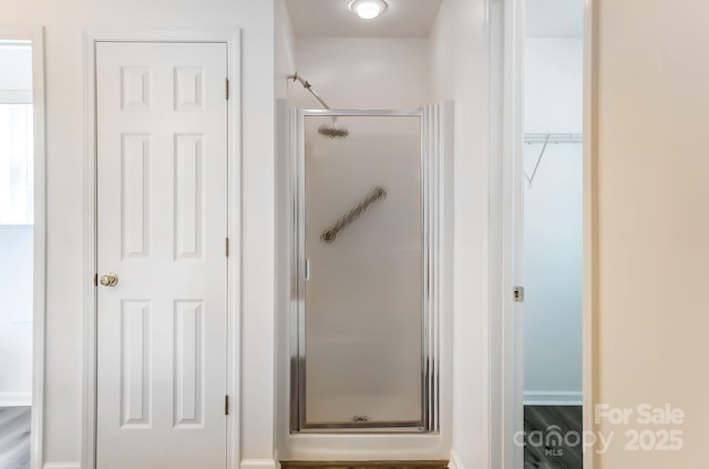 bathroom featuring a spacious closet and a stall shower