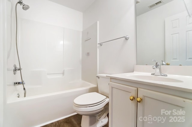 bathroom with wood finished floors, visible vents, toilet, vanity, and tub / shower combination