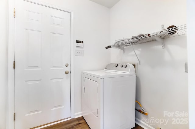 washroom with washer / dryer, dark wood-type flooring, laundry area, and baseboards