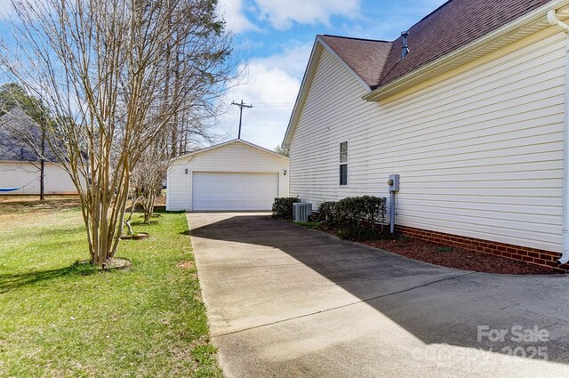 view of side of property with cooling unit, a garage, a lawn, a shingled roof, and an outdoor structure