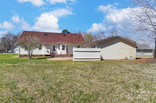 rear view of property featuring crawl space, a lawn, a patio, entry steps, and roof with shingles