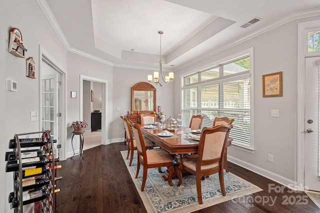 dining space with a tray ceiling, plenty of natural light, and dark hardwood / wood-style floors