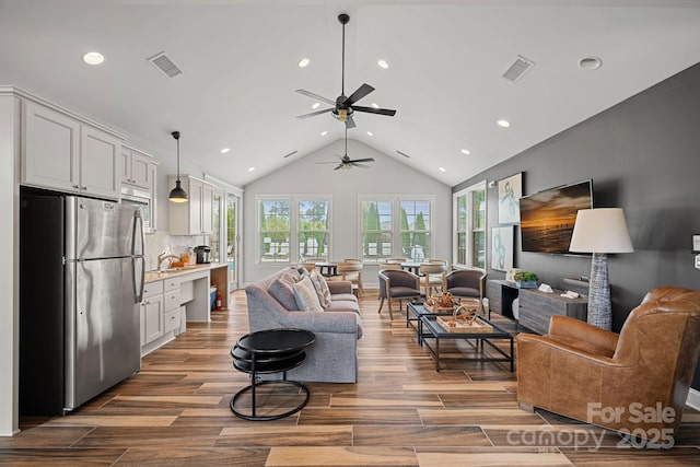 living room featuring hardwood / wood-style flooring, sink, and high vaulted ceiling