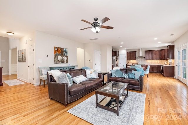 living room featuring light hardwood / wood-style floors, ceiling fan, and sink