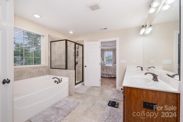 bathroom with vanity and separate shower and tub