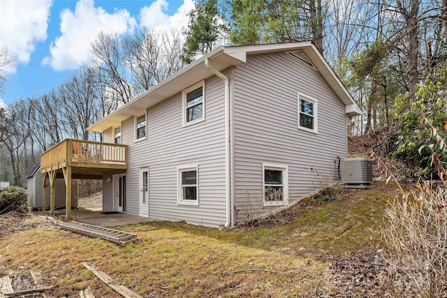 view of home's exterior featuring a deck, central AC unit, and a lawn