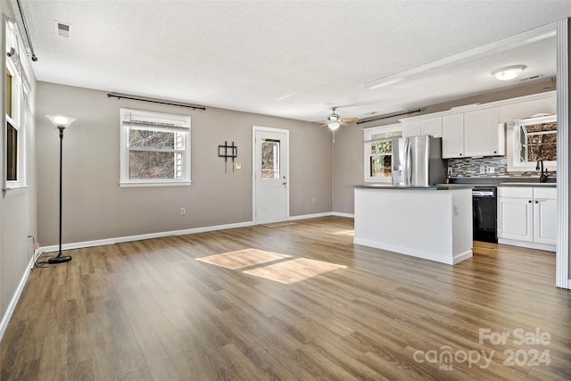 kitchen featuring white cabinetry, plenty of natural light, stainless steel refrigerator with ice dispenser, and light wood-type flooring