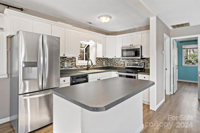 kitchen featuring white cabinets, appliances with stainless steel finishes, light hardwood / wood-style flooring, and sink