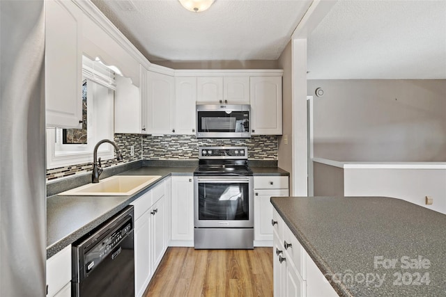 kitchen featuring sink, white cabinets, stainless steel appliances, and light hardwood / wood-style flooring