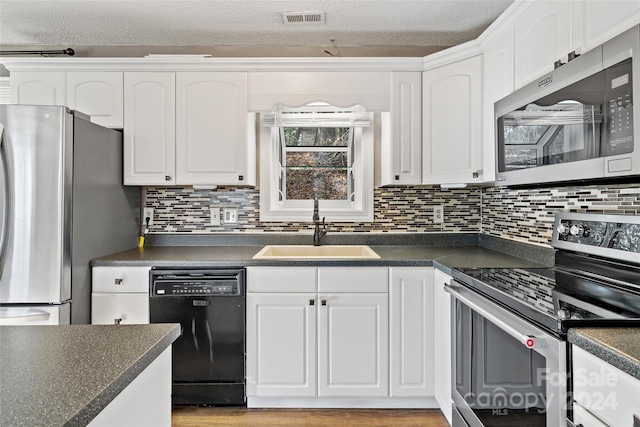 kitchen with white cabinets, appliances with stainless steel finishes, and sink