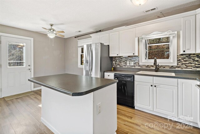 kitchen with sink, light hardwood / wood-style flooring, stainless steel fridge with ice dispenser, black dishwasher, and white cabinetry