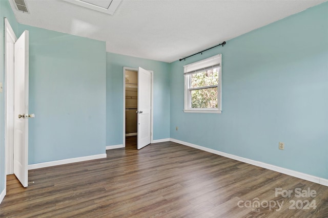 unfurnished bedroom with dark wood-type flooring and a textured ceiling