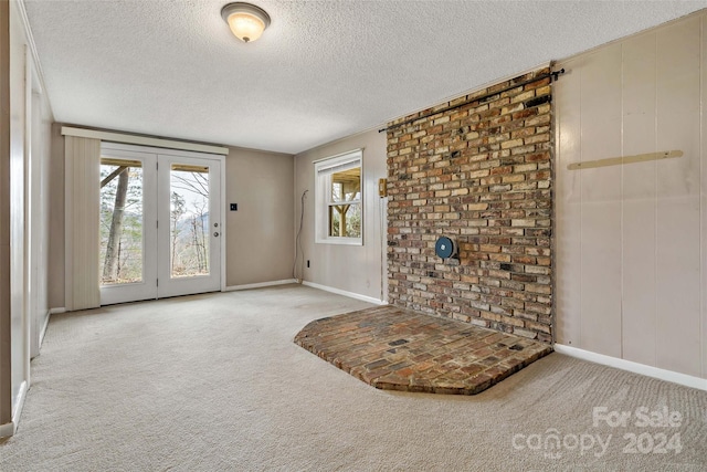 carpeted foyer with a textured ceiling