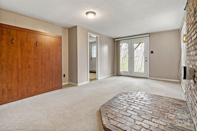 unfurnished room with light colored carpet and a textured ceiling