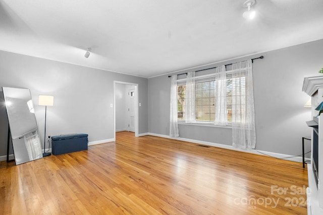 unfurnished living room featuring light wood-type flooring and a fireplace