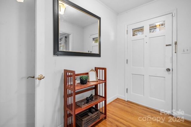 foyer entrance featuring wood-type flooring and ornamental molding