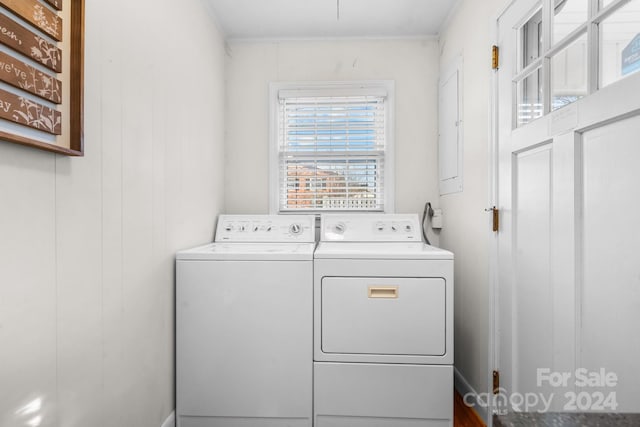 clothes washing area with wooden walls, crown molding, and independent washer and dryer