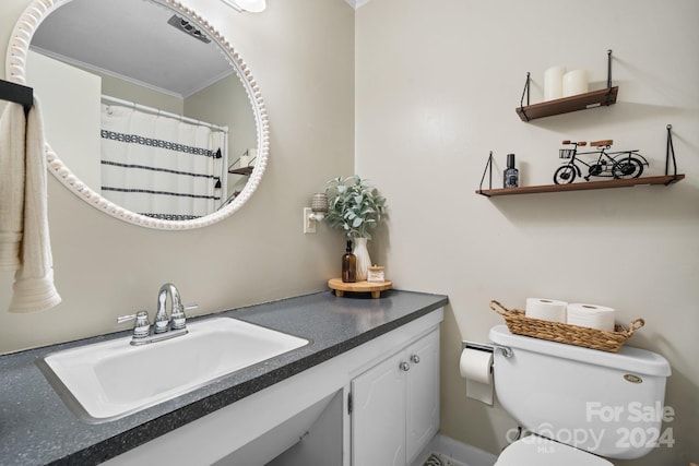 bathroom with toilet, vanity, and ornamental molding