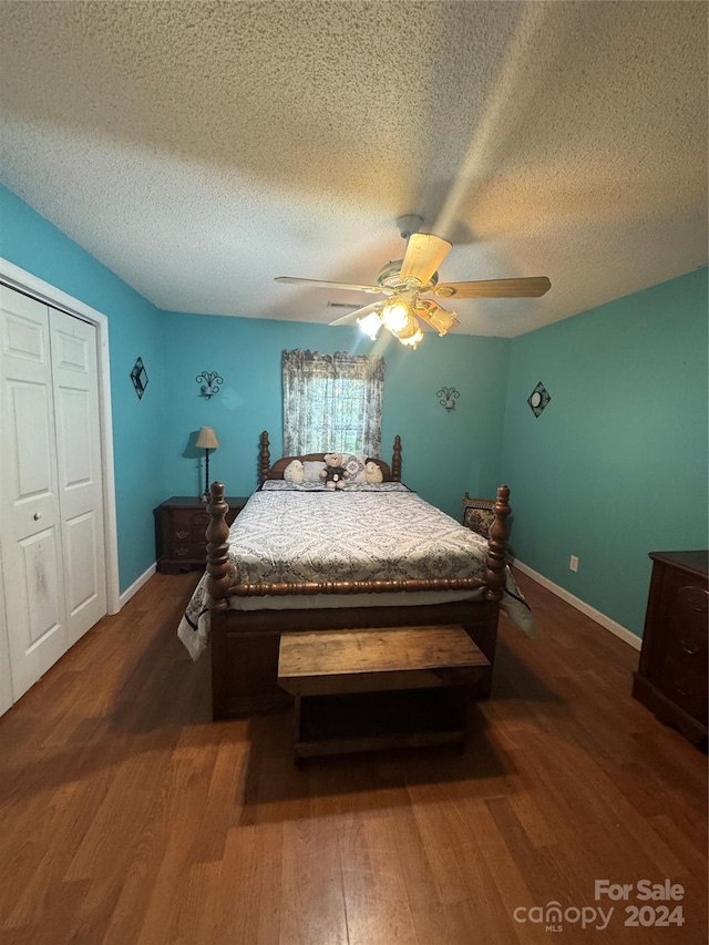 bedroom with a closet, ceiling fan, hardwood / wood-style flooring, and a textured ceiling