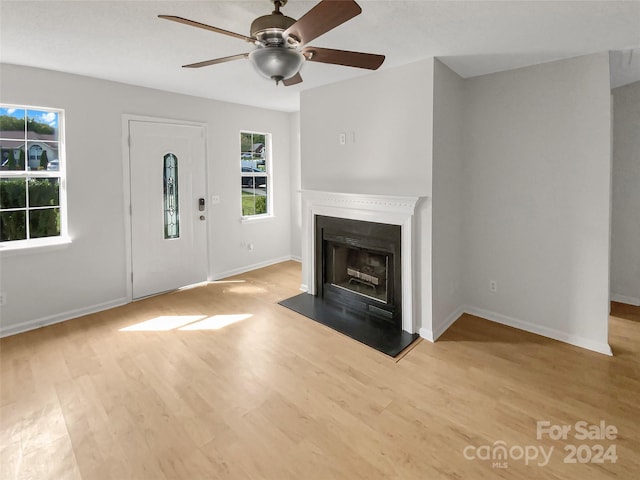 unfurnished living room featuring light wood-type flooring and ceiling fan